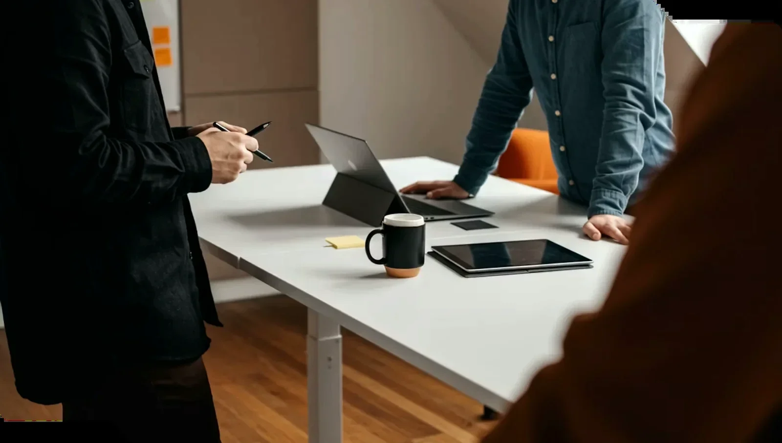 The design team gathered around a model and drawings at a white table