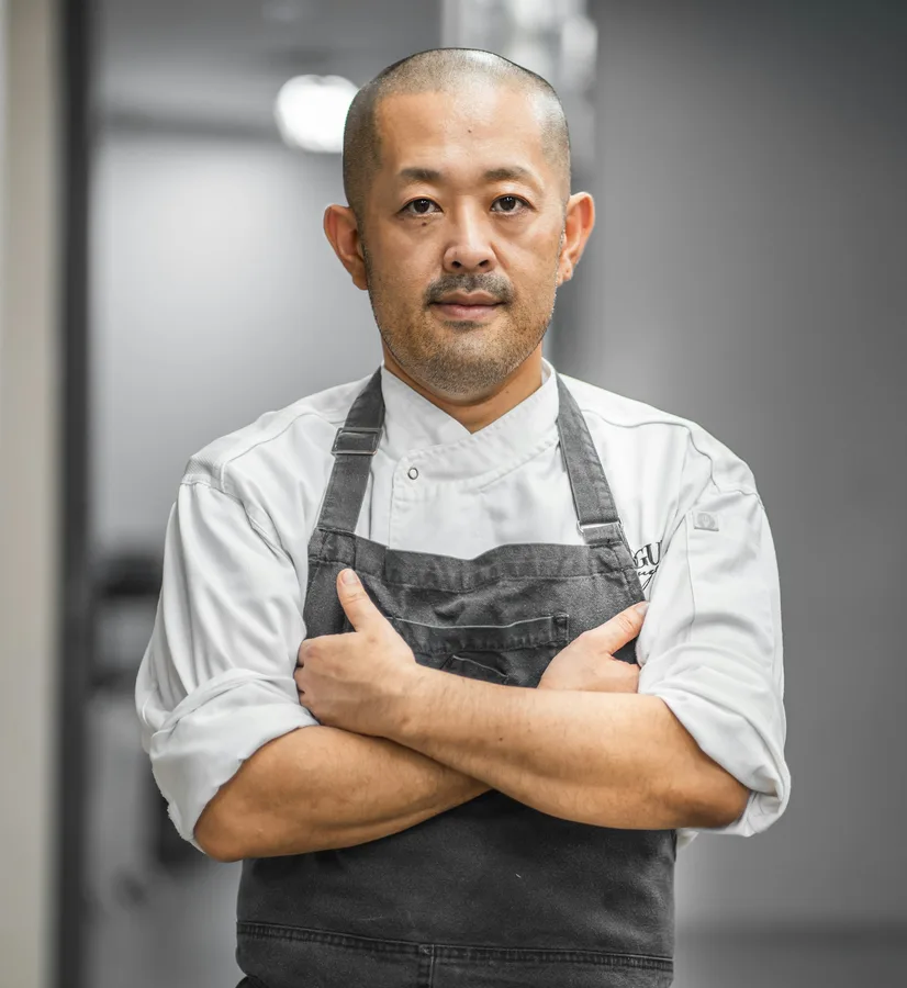 Kenji Mori in a white jacket and grey apron, arms crossed
