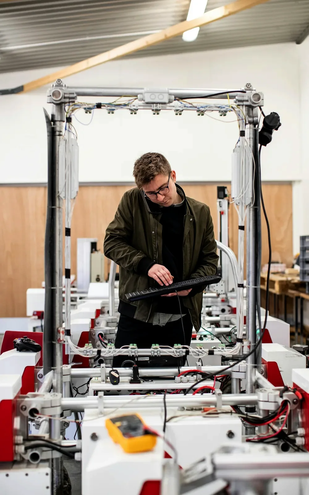 Ostrander engineer checking a tablet inside a robot cell