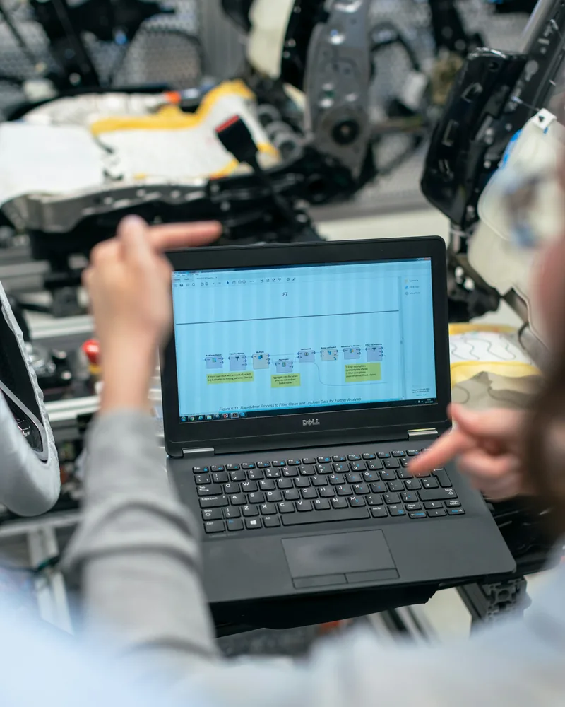 Engineer programming a cell on a laptop