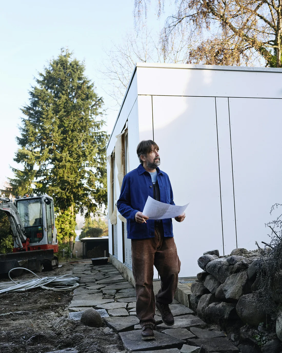 A Hadley & Fox project manager in a hard hat checking drawings on site