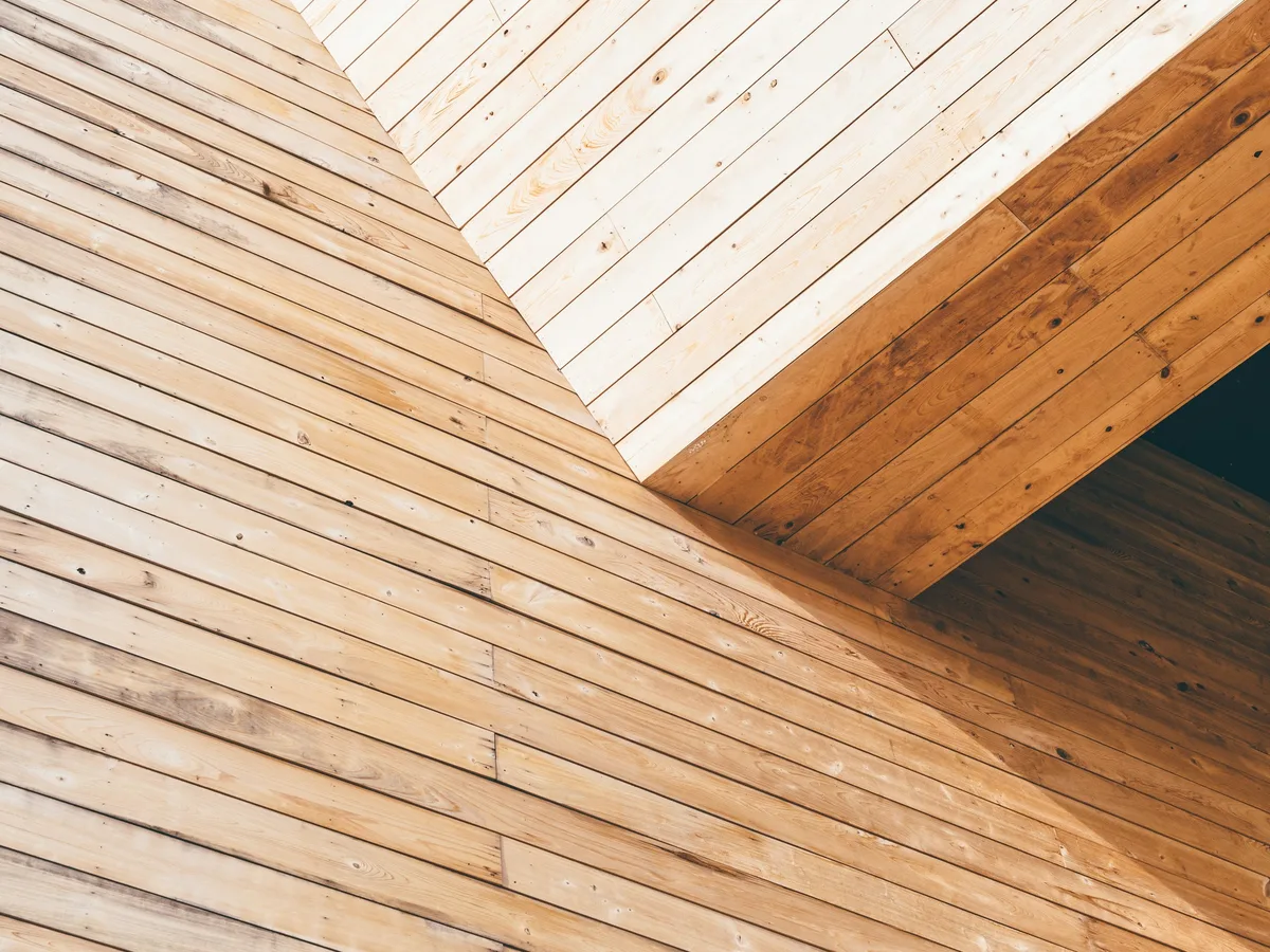 Close view of pale vertical wooden planks meeting at a corner