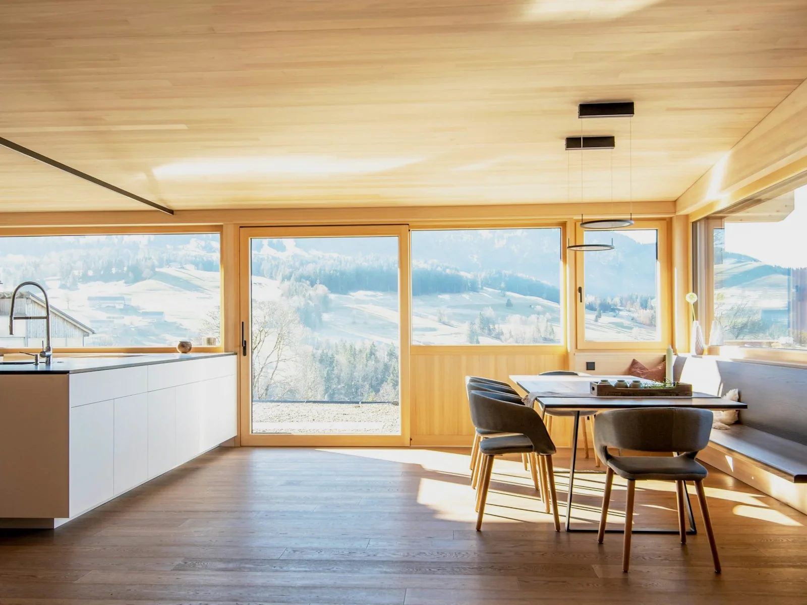 Bright timber kitchen and dining room with a long window over fields
