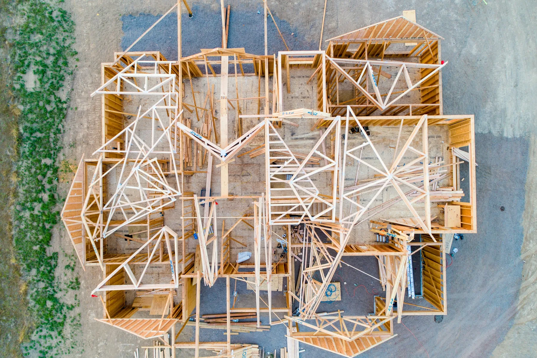 Aerial view of a timber house frame with roof trusses on a building site