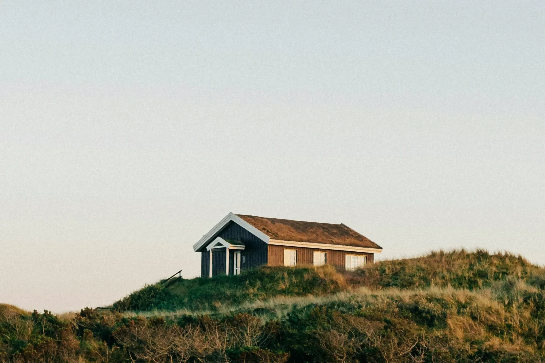Dark summer house on a grassy dune