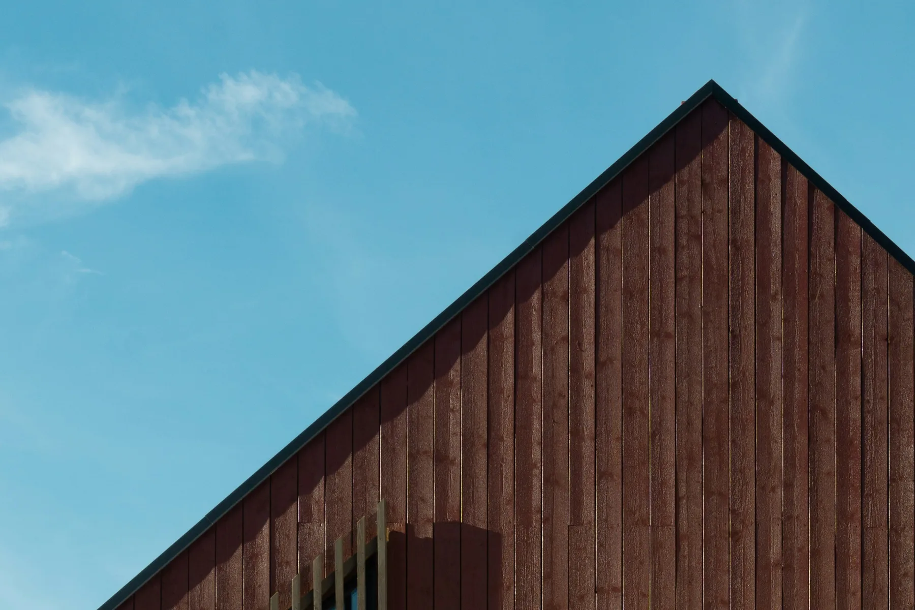 Dark timber gable of Hus ved Kalø against a clear blue sky