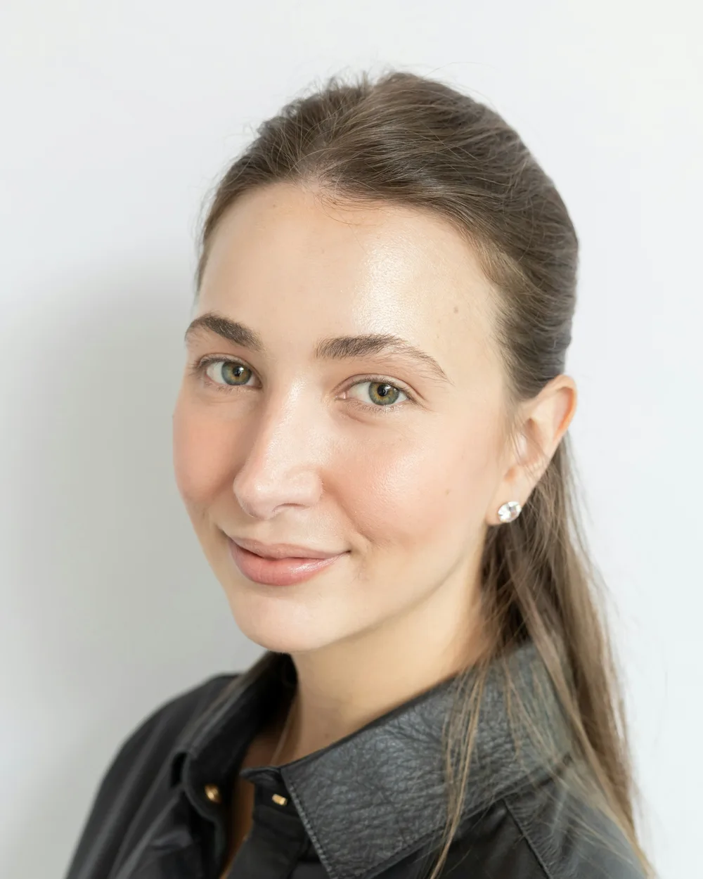 Maja Holm smiling against a pale wall