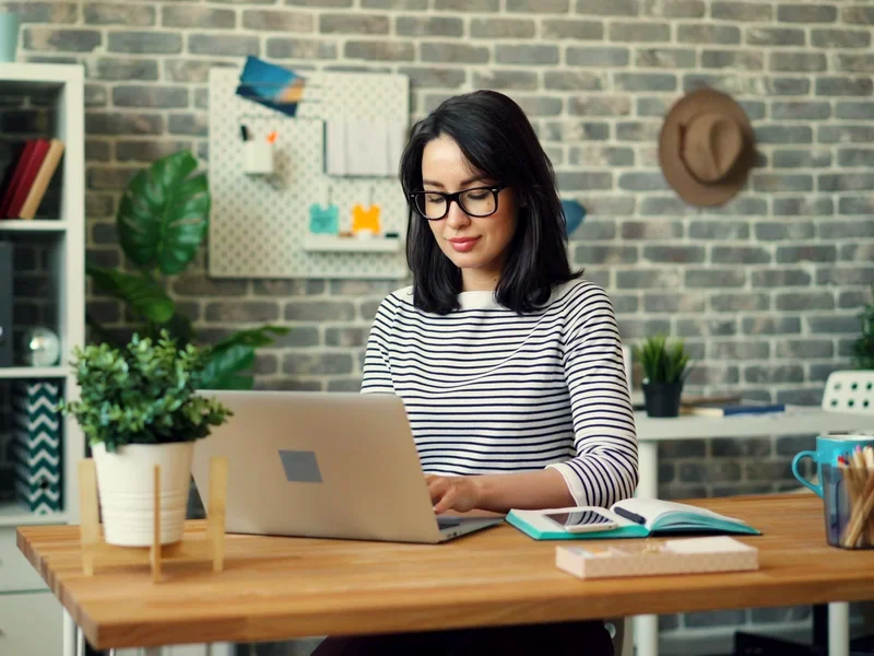 A client smiling at her laptop as the filing receipt arrives