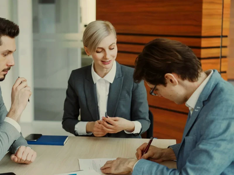 A client signing the summary of their figures at a table