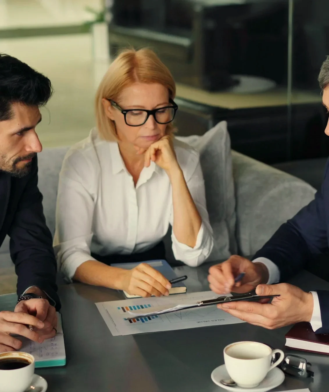 Ruth Marrow going through a client's figures with two colleagues at a table