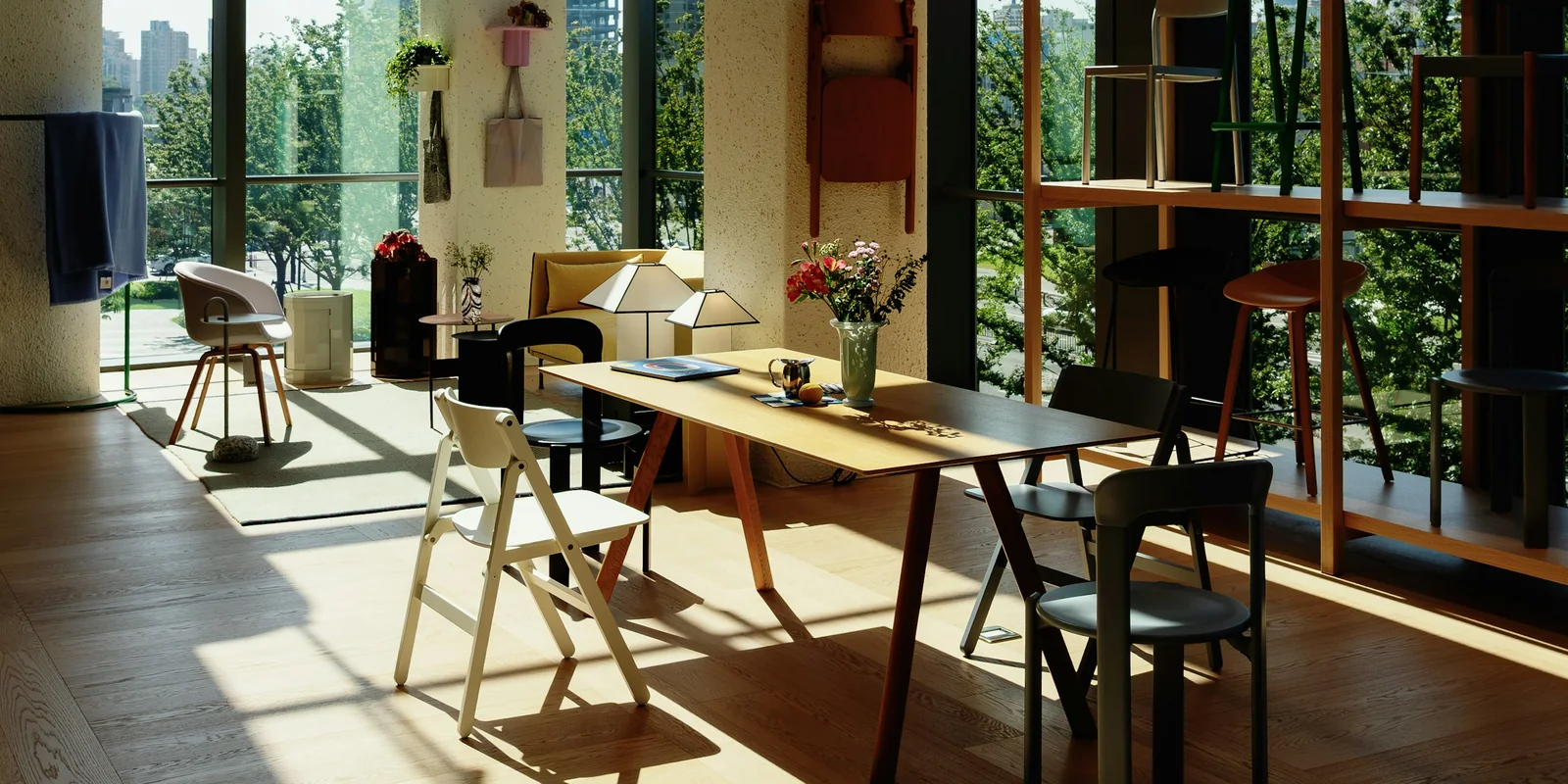 Tall windows throw long afternoon shadows across a timber floor, a table and chairs