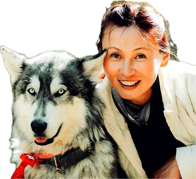 Dr. Maya Ortiz smiling beside a husky