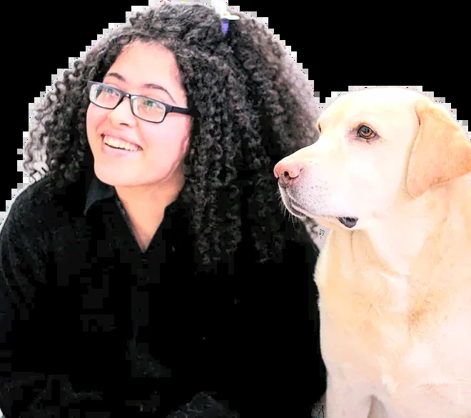 Priya Nair laughing next to a yellow Labrador