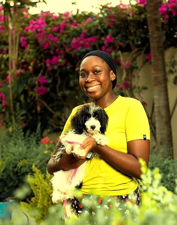 Dr. Maya Ortiz smiling and holding a fluffy black-and-white puppy