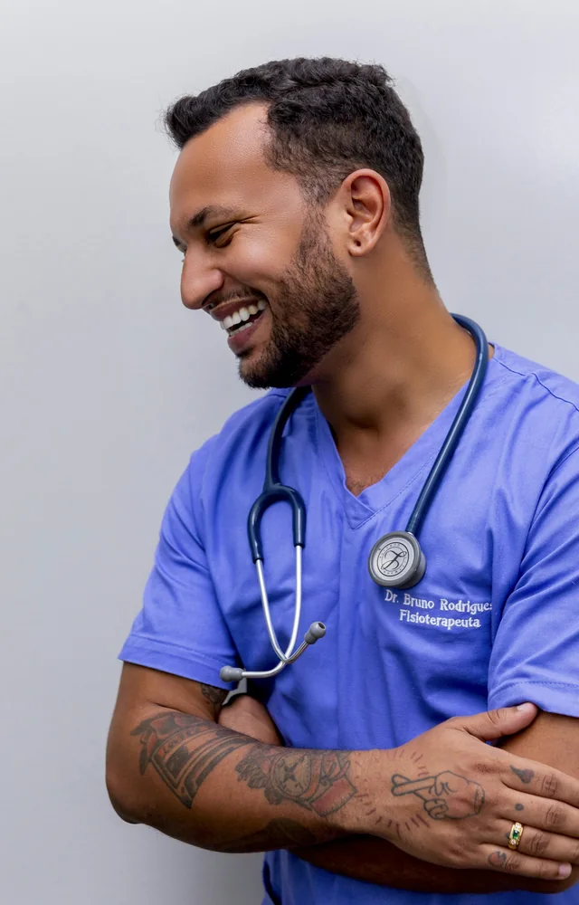 Laughing healthcare assistant in blue scrubs with a stethoscope